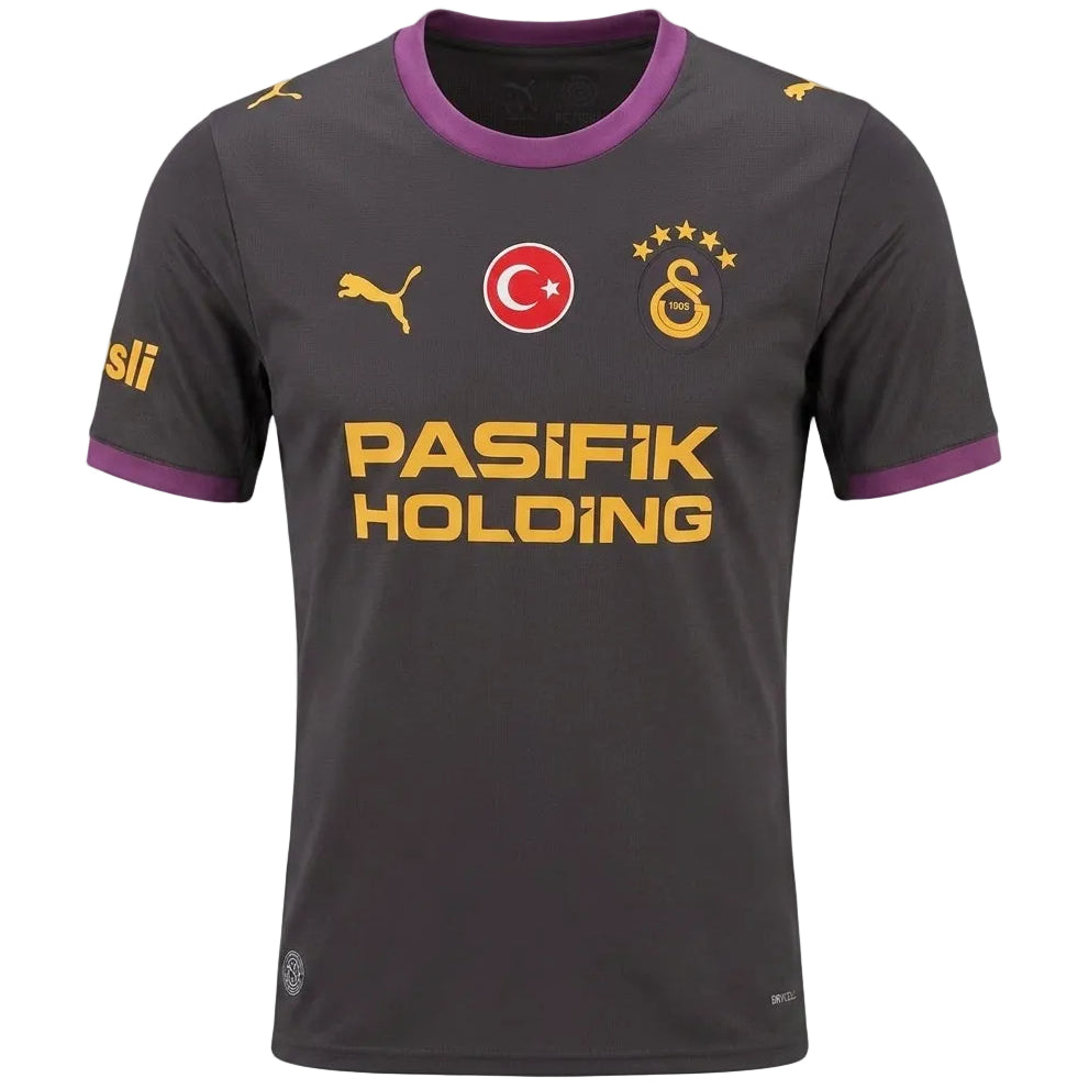 A dark gray Galatasaray soccer jersey with purple collar and sleeve trim, featuring yellow and red logos including the Turkish flag and 'PASIFIK HOLDING' sponsor text.