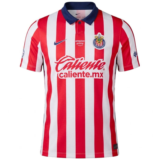 A red and white vertically striped soccer jersey with a navy blue collar, featuring the Chivas crest, swoosh, and Caliente sponsor logo on the front.