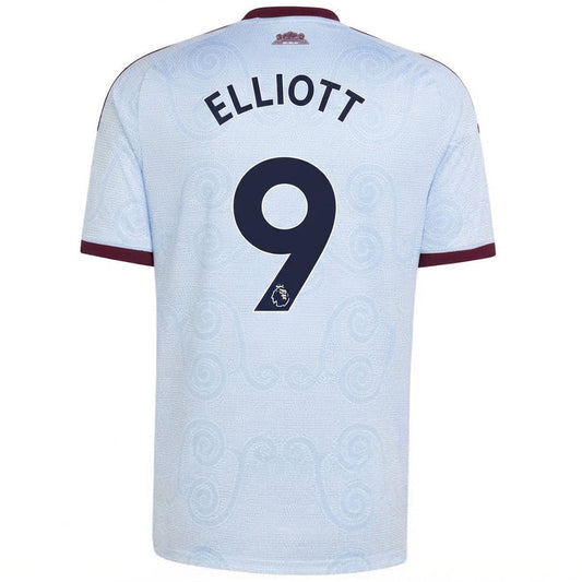 Back view of a light blue Manchester City football jersey with 'ELLIOTT' and the number '9' printed in navy on the back, featuring maroon trim on the collar and sleeve cuffs.