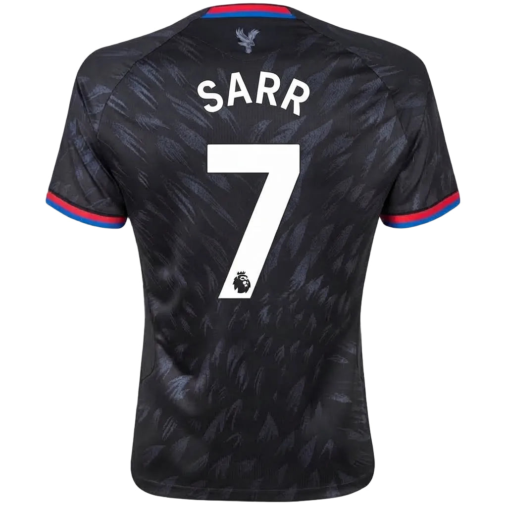 Back view of a Tottenham Hotspur football jersey with 'SARR' and the number 7 printed in white, featuring a dark patterned design with red and blue trim on the collar and sleeve cuffs.