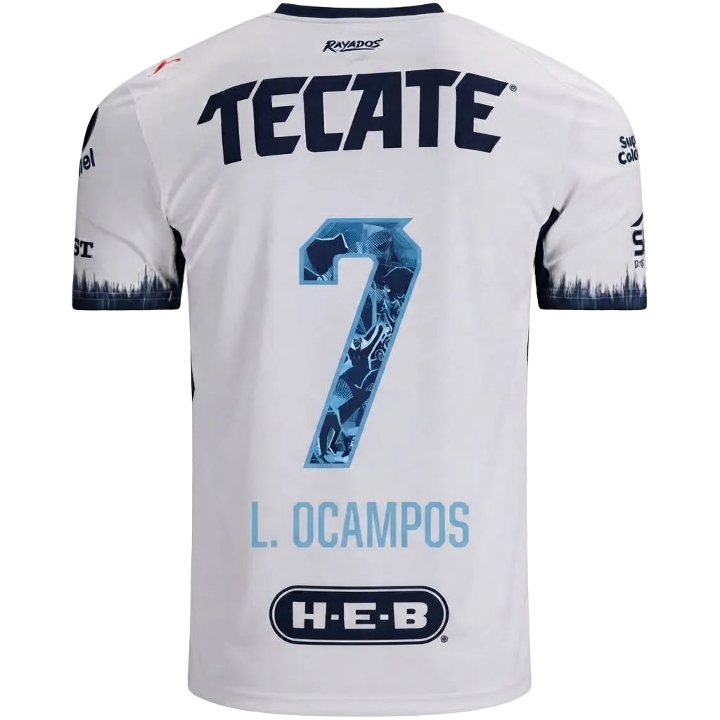White short-sleeve soccer jersey shown from the back, featuring large navy 'TECATE' lettering, a blue patterned number 7, 'L. OCAMPOS' in light blue, and an H-E-B sponsor logo near the bottom.