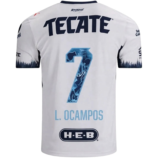 White short-sleeve soccer jersey shown from the back, featuring large navy 'TECATE' lettering, a blue patterned number 7, 'L. OCAMPOS' in light blue, and an H-E-B sponsor logo near the bottom.